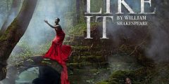 Poster for As You Like It, featuring a Black woman in a red dress gesturing and a Black woman in black clothes sitting in a forest next to a ruined bridge.