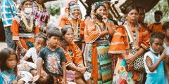 Group of women and children in Mindanao, Philippines wearing traditional orange stripe robes
