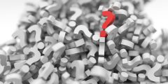 Bold contrast of red question mark amongst white question marks
