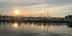 a collection of boats on a lake at sunset