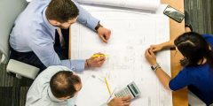 Three people reviewing drawings