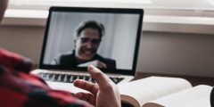 Young man in a virtual meeting with another man.