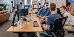 Three men in the workplace talking.