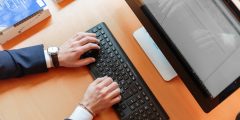 Man typing on computer in suit