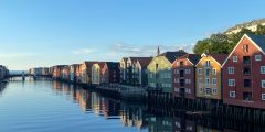 A picture looking down the river at the houses from trondheim old bridge at sunset.