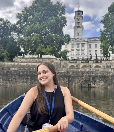 Claudia Medina Munoz in a boat on the lake with the Trent Building in the background