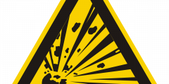Warning triangle yellow with black border in one corner a round bomb explodes radiating out into the corners of the triangle