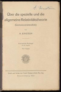 Photograph of the printed title page of a book with handwritten signature in the corner