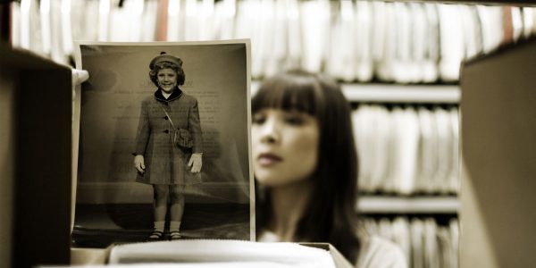 Learning from the past course image: Young woman reviewing images in a library.
